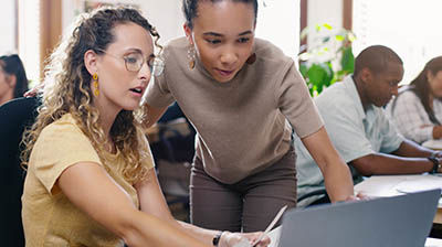 Epic Quotes Two women working together on a computer while in an office